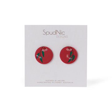 A pair of red stud earings with pink and green gum blossom print made by Polymer clay